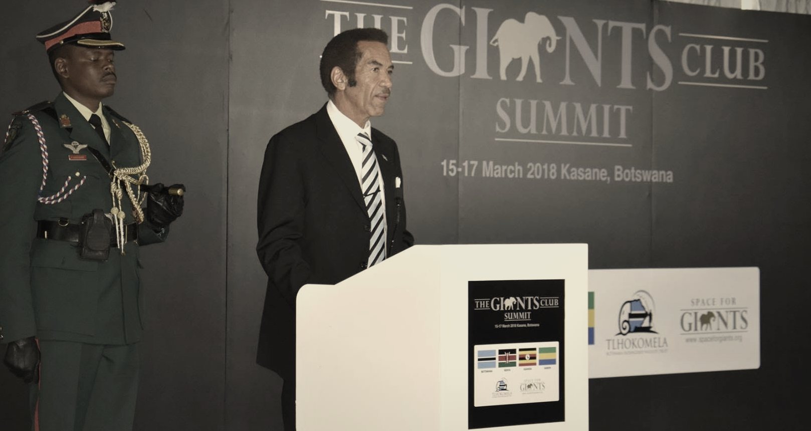 Ian Khama speaking at the Giants Club Summit lectern, flanked by an honour guard